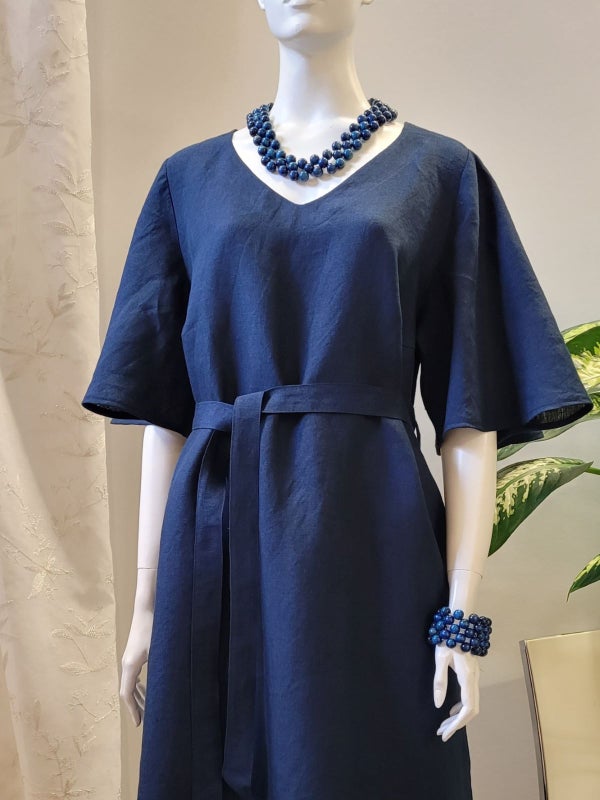 M&ouml;rkbl&aring; festlig linnkl&auml;nning. Knyt b&auml;ltet l&auml;tt runt midjan.