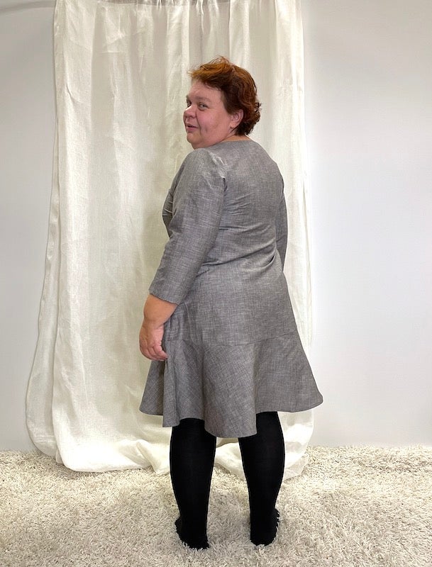 Gr&aring; festkl&auml;nning, fin yta. Modellen &auml;r 163 cm l&aring;ng och anv&auml;nda storlek XL.